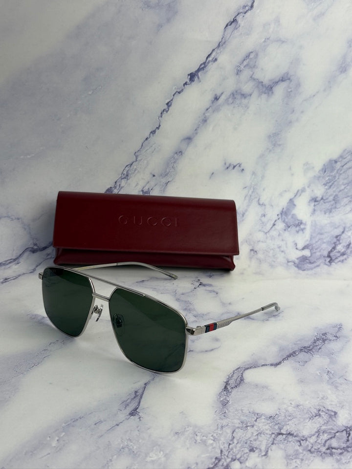 Silver metal aviator sunglasses with green lenses and red Gucci case