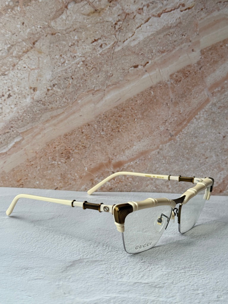 Gucci ivory cat-eye eyeglass frames with gold bamboo hinge detail, side view