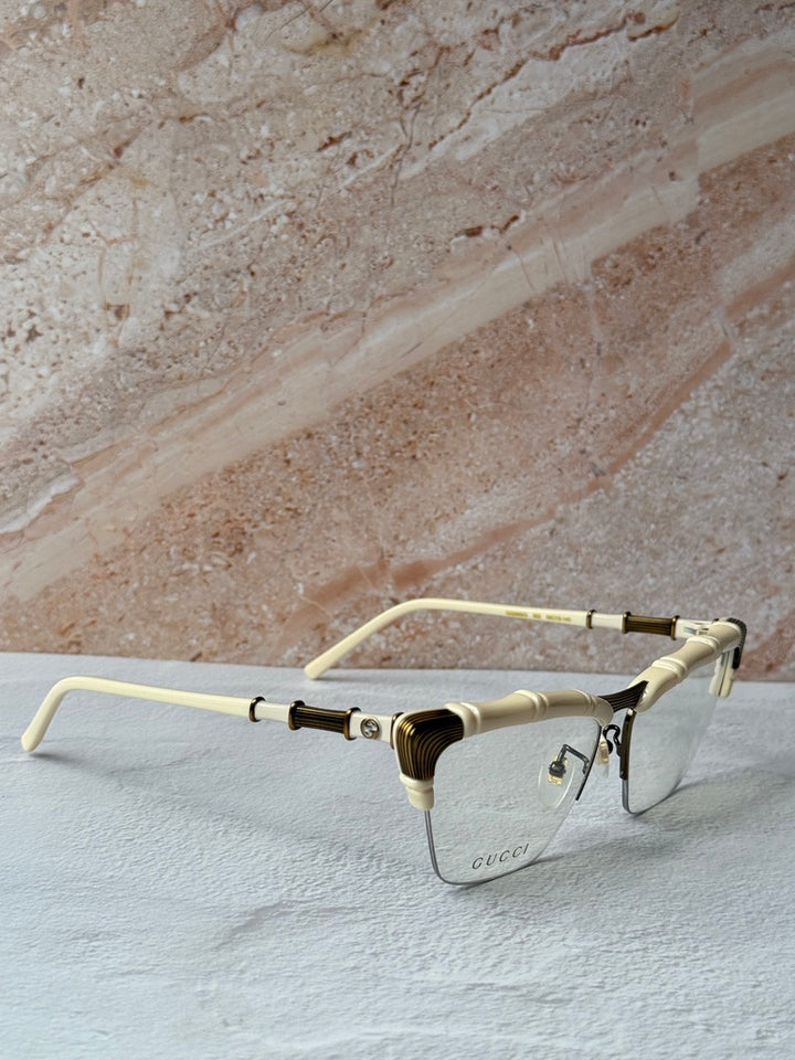Gucci ivory cat-eye eyeglass frames with gold bamboo hinge detail, side view