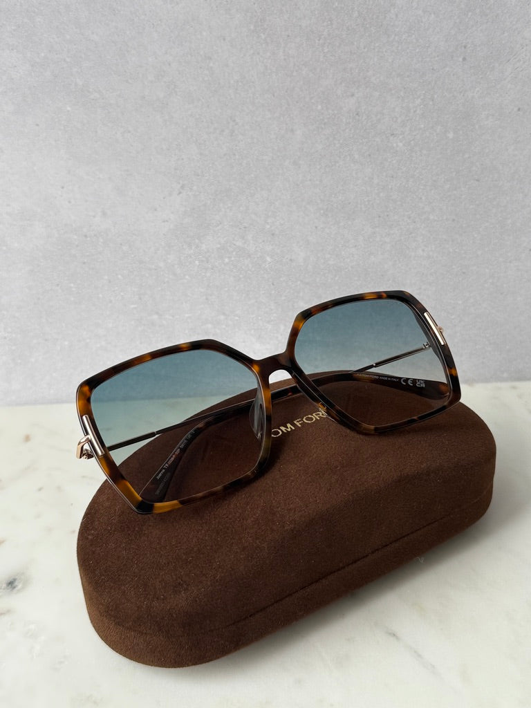 Havana brown square sunglasses with dark lenses, resting on brown case