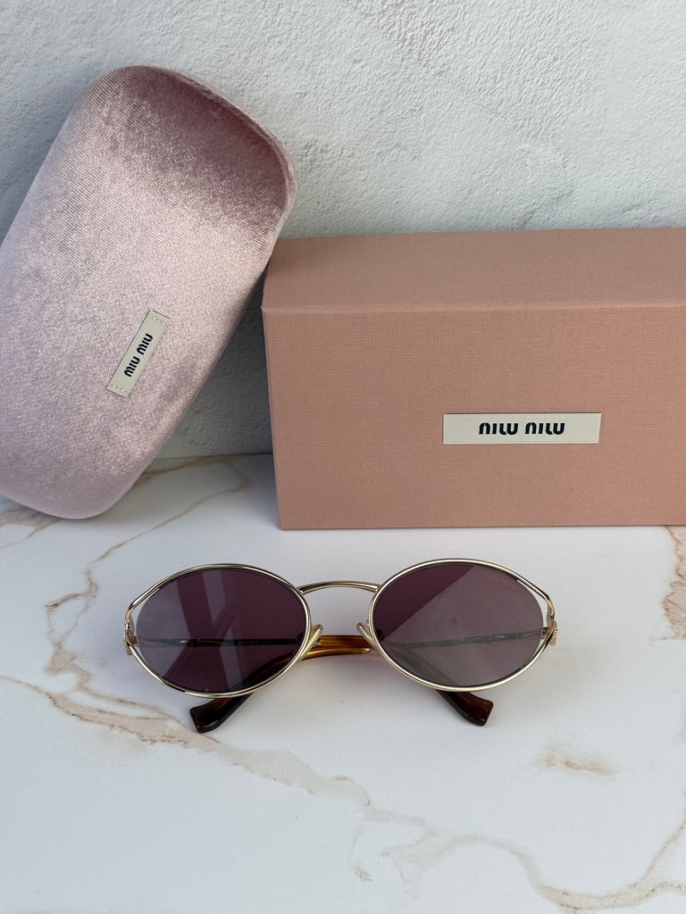 Miu Miu oval sunglasses with purple lenses, gold frame, shown with case and box.