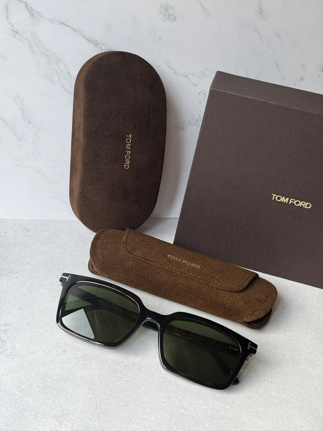 Rectangular clip-on sunglasses with dark green lenses, shown with case and pouch