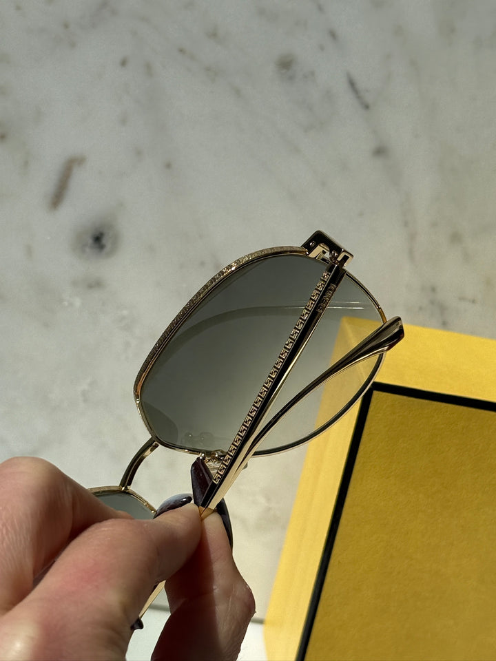Fendi gold-tone metal sunglasses side view with green tinted lens and etched temple