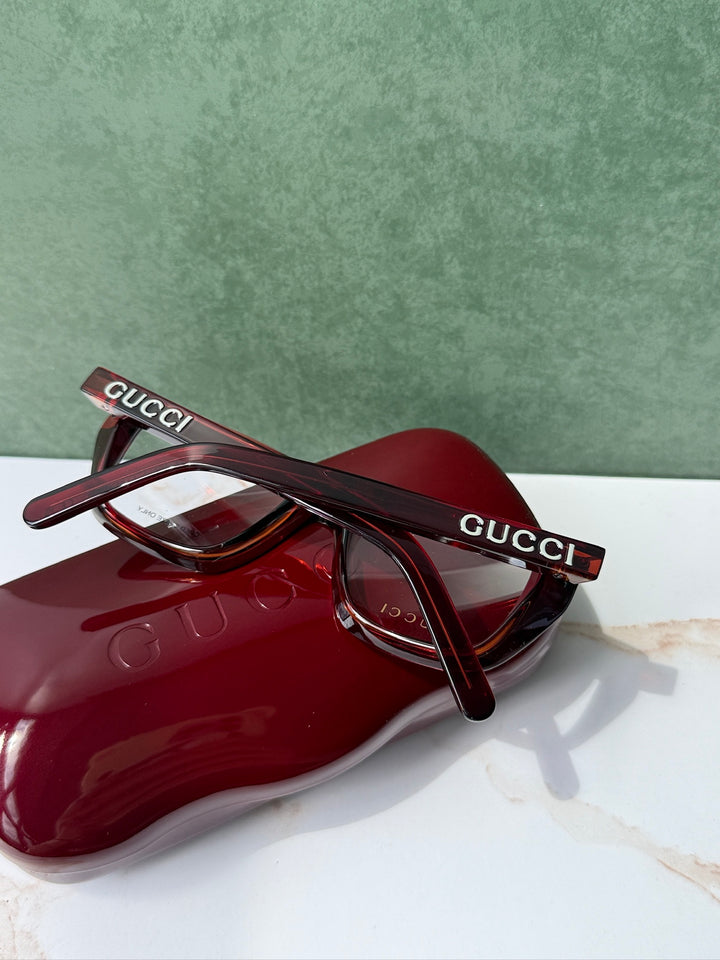 Dark red Gucci eyeglass frames with logo on temple and red case