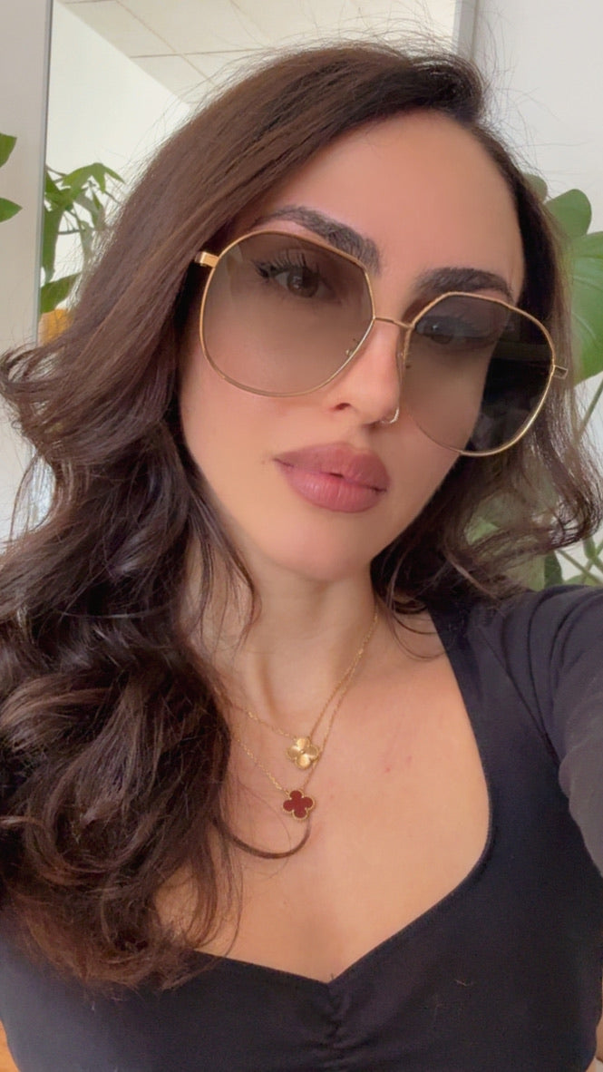 Fendi gold-tone metal sunglasses on face, green tinted round lenses