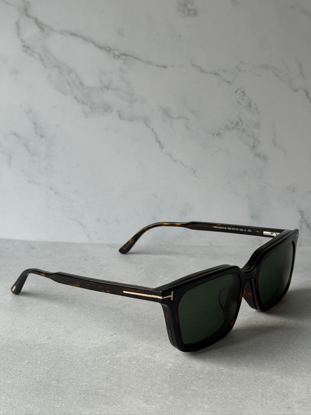 Diagonal view of rectangular sunglasses with dark frame and dark green lenses