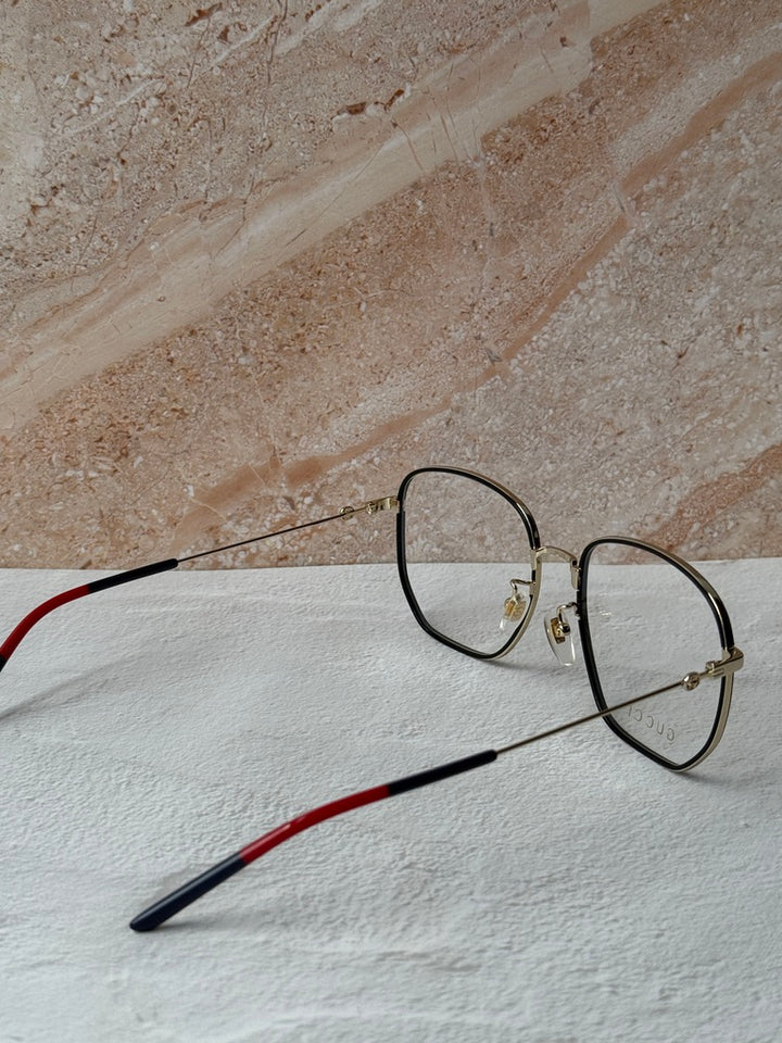 Gucci square eyeglasses close view of black frame and gold bridge, clear lenses