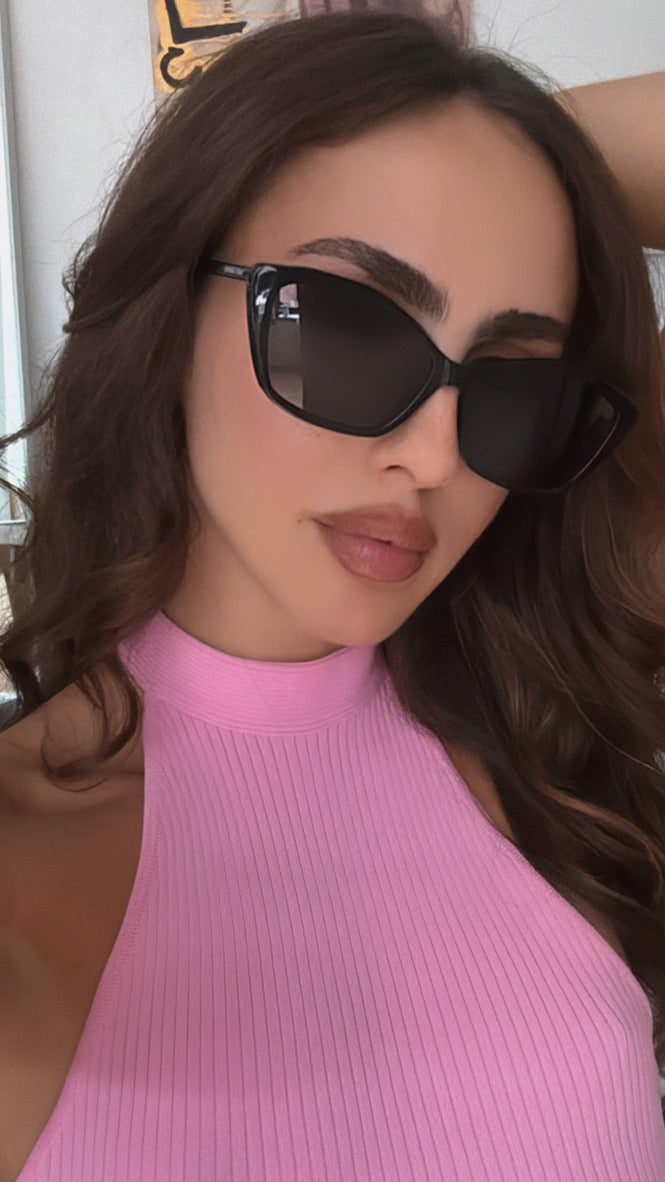 Black cat-eye sunglasses with dark lenses, angled on face