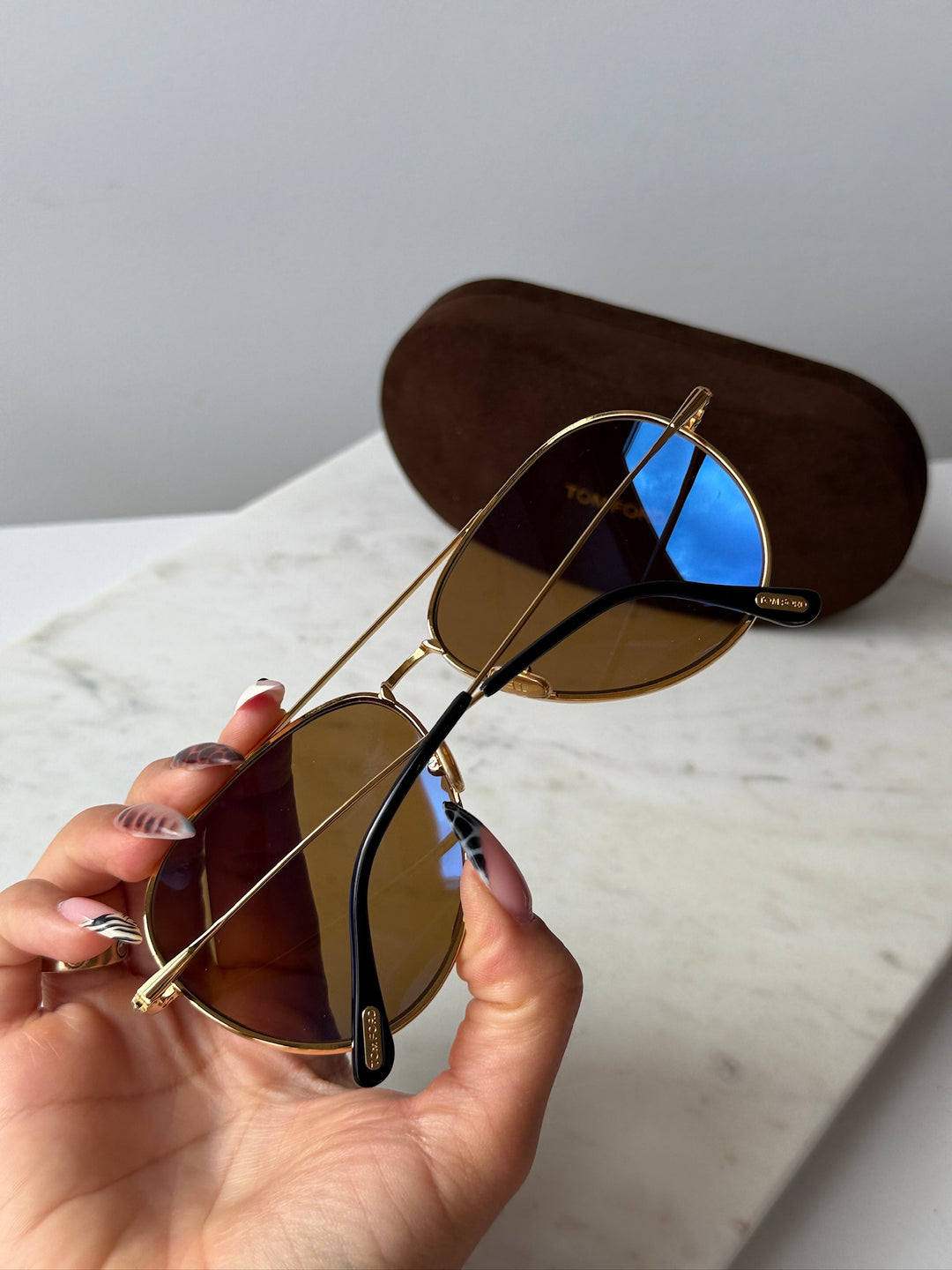 Gold-tone aviator sunglasses with brown lenses and temple detail