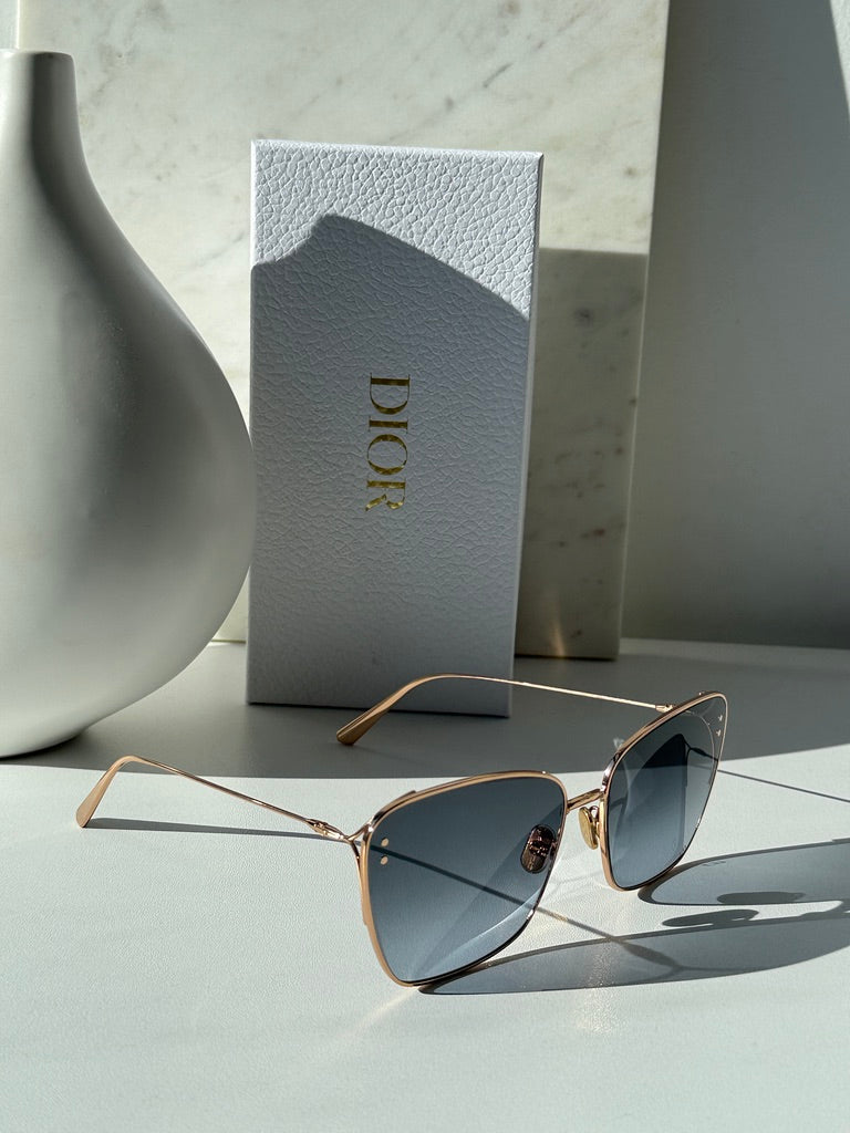 Dior gold-tone square sunglasses with dark grey gradient lenses, angled view