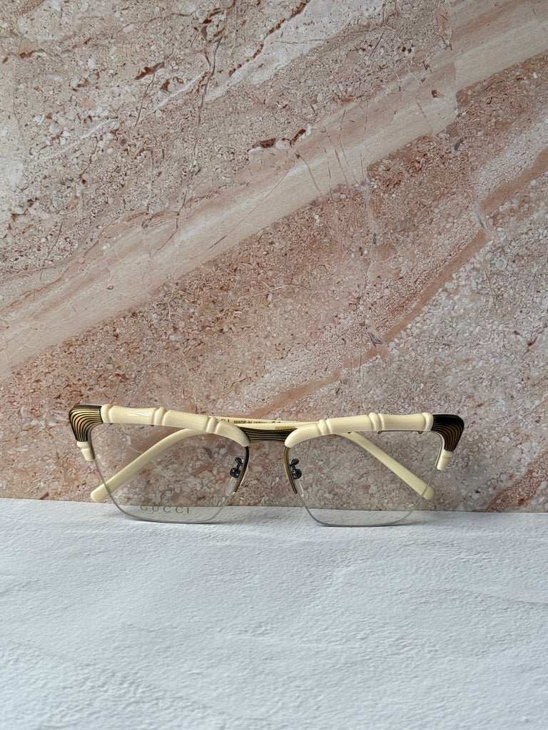 Gucci ivory cat-eye eyeglass frames with gold bamboo temples, wide angle