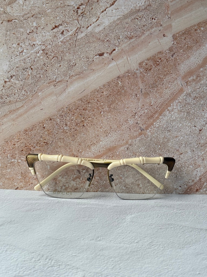Gucci ivory cat-eye eyeglass frames with gold bamboo temples, wide angle