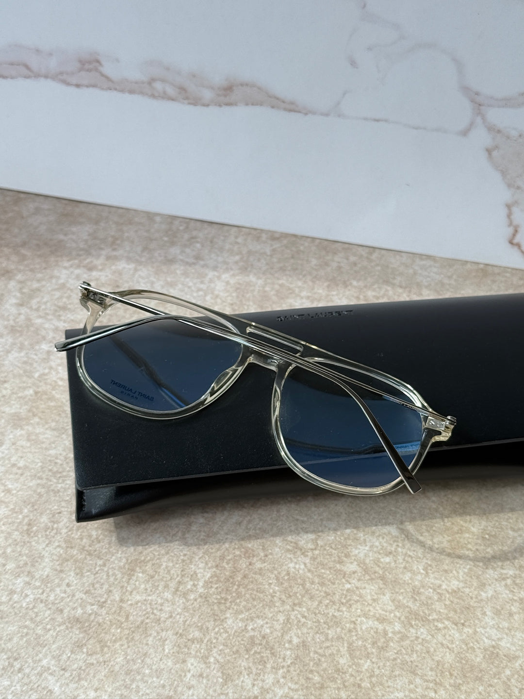 Clear aviator eyeglass frames with blue-tinted lenses and metal bridge
