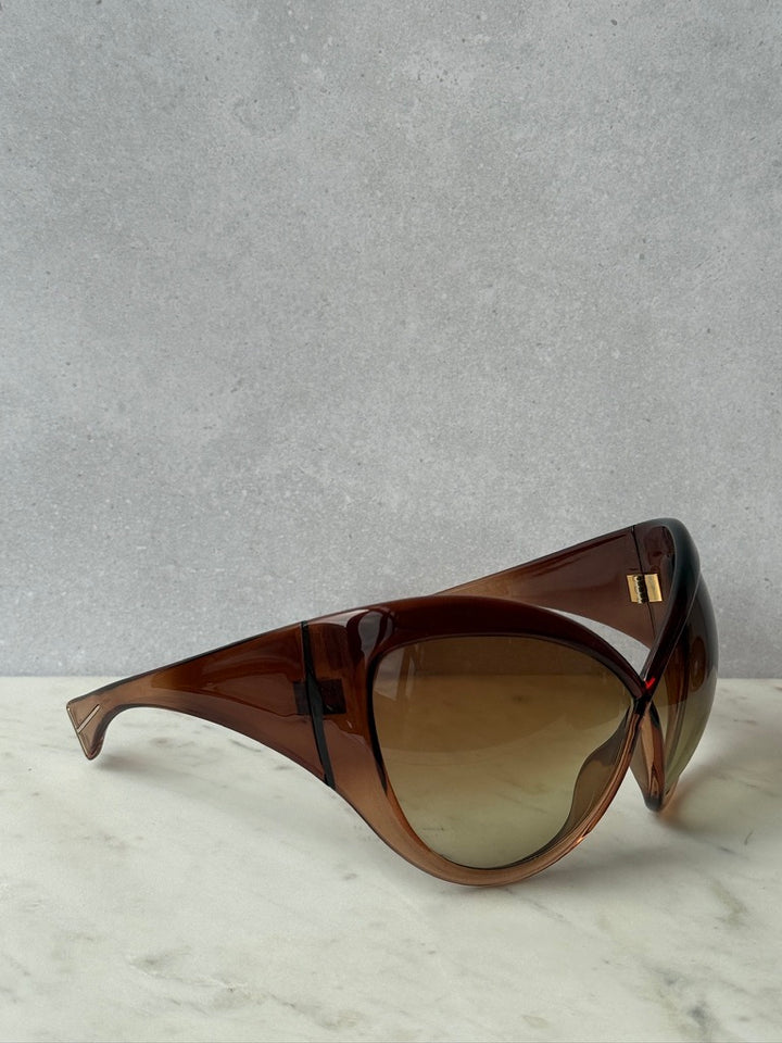 Side angle of brown mask sunglasses showing wide sculpted arms and gradient lenses
