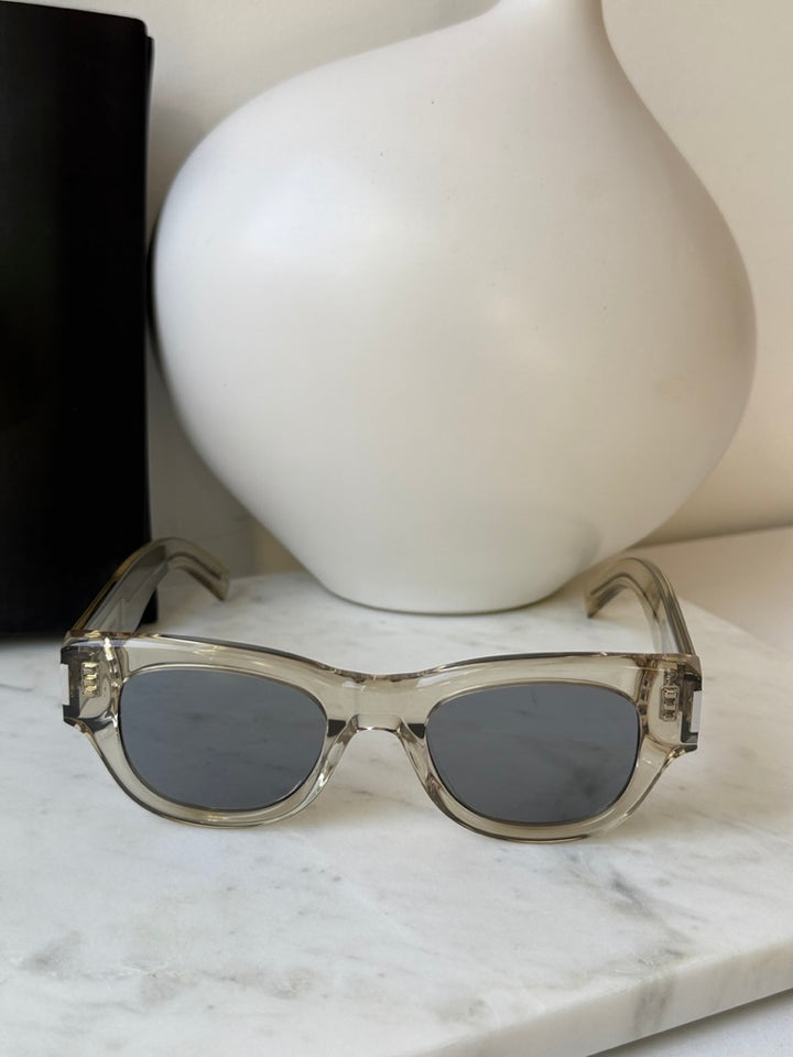 Saint Laurent SL573 clear mirror sunglasses close-up with dark lenses and transparent frame
