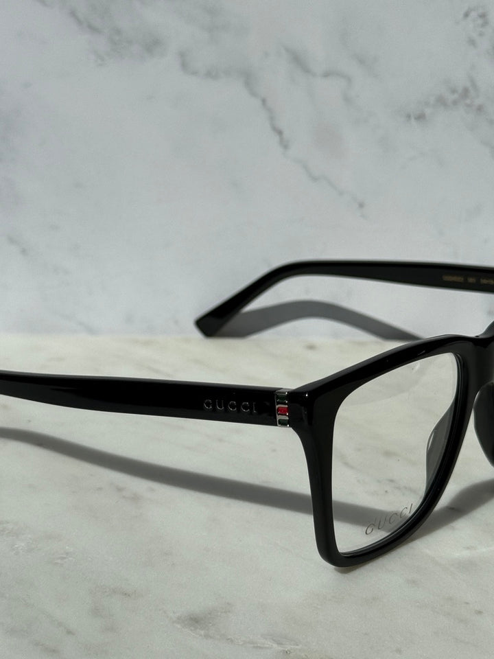 Black rectangular eyeglass frame with Gucci logo detail on hinge and temples