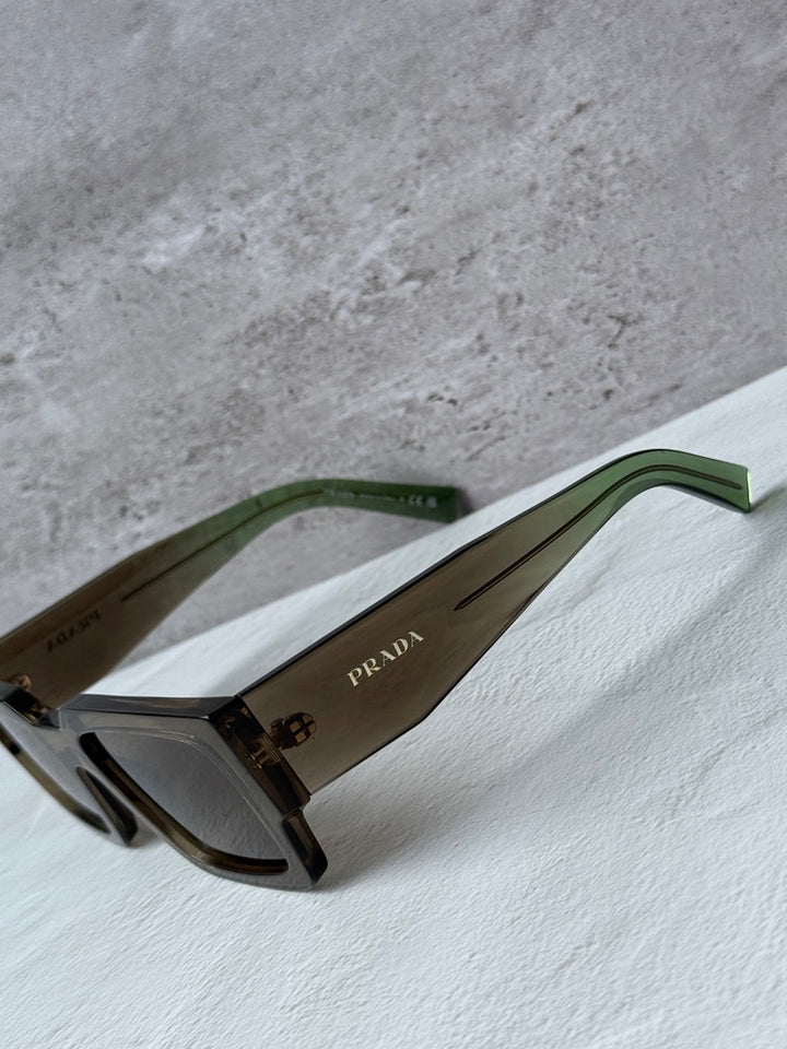 Prada sunglasses with transparent brown frames, brown lenses, green-tinted temples