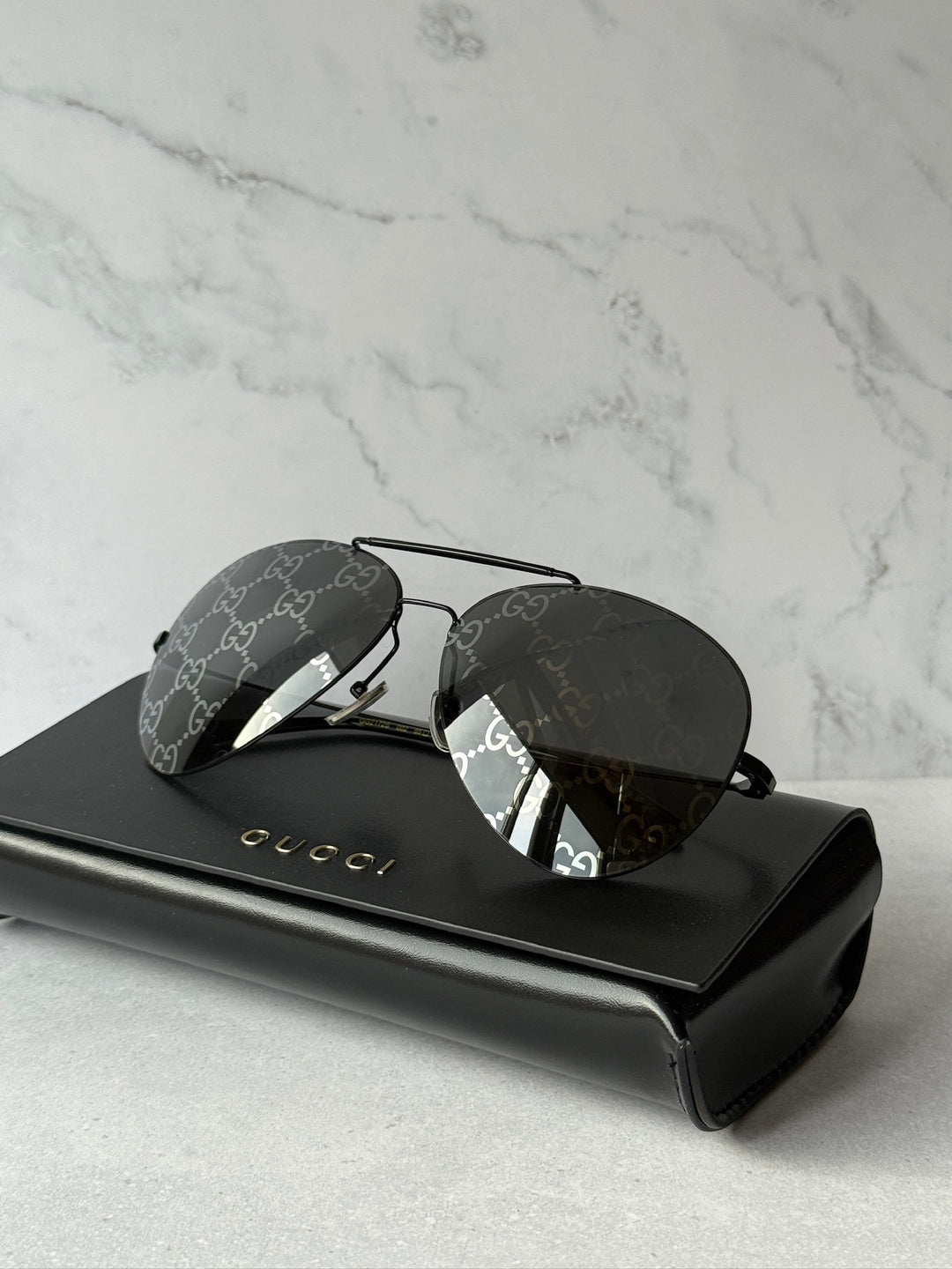 Aviator sunglasses with dark lenses and GG logo frame on black hard case