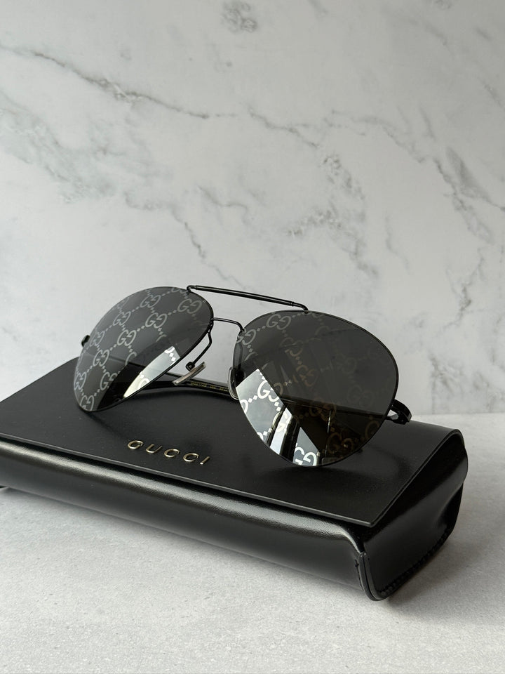 Aviator sunglasses with dark lenses and GG logo frame on black hard case