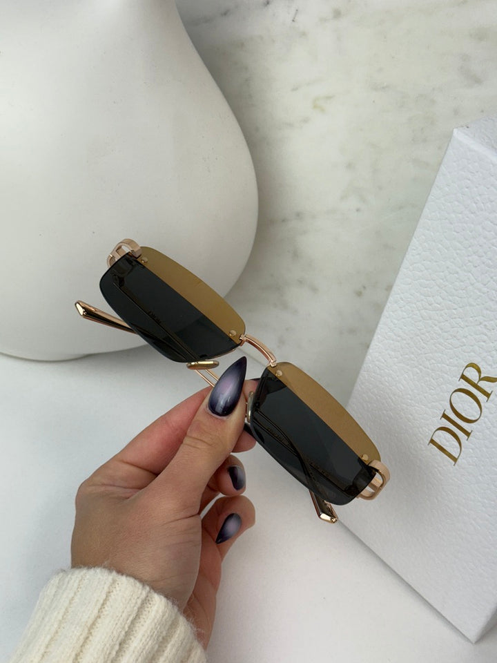 Rimless sunglasses with gold-toned arms and dark rectangular lenses