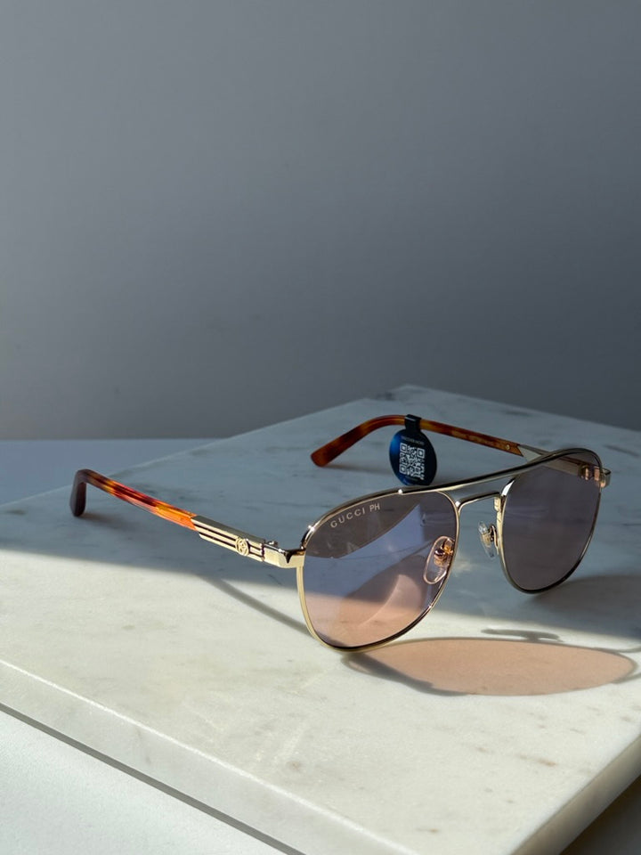 Gucci gold pilot sunglasses with photochromic lenses and tortoise temple tips