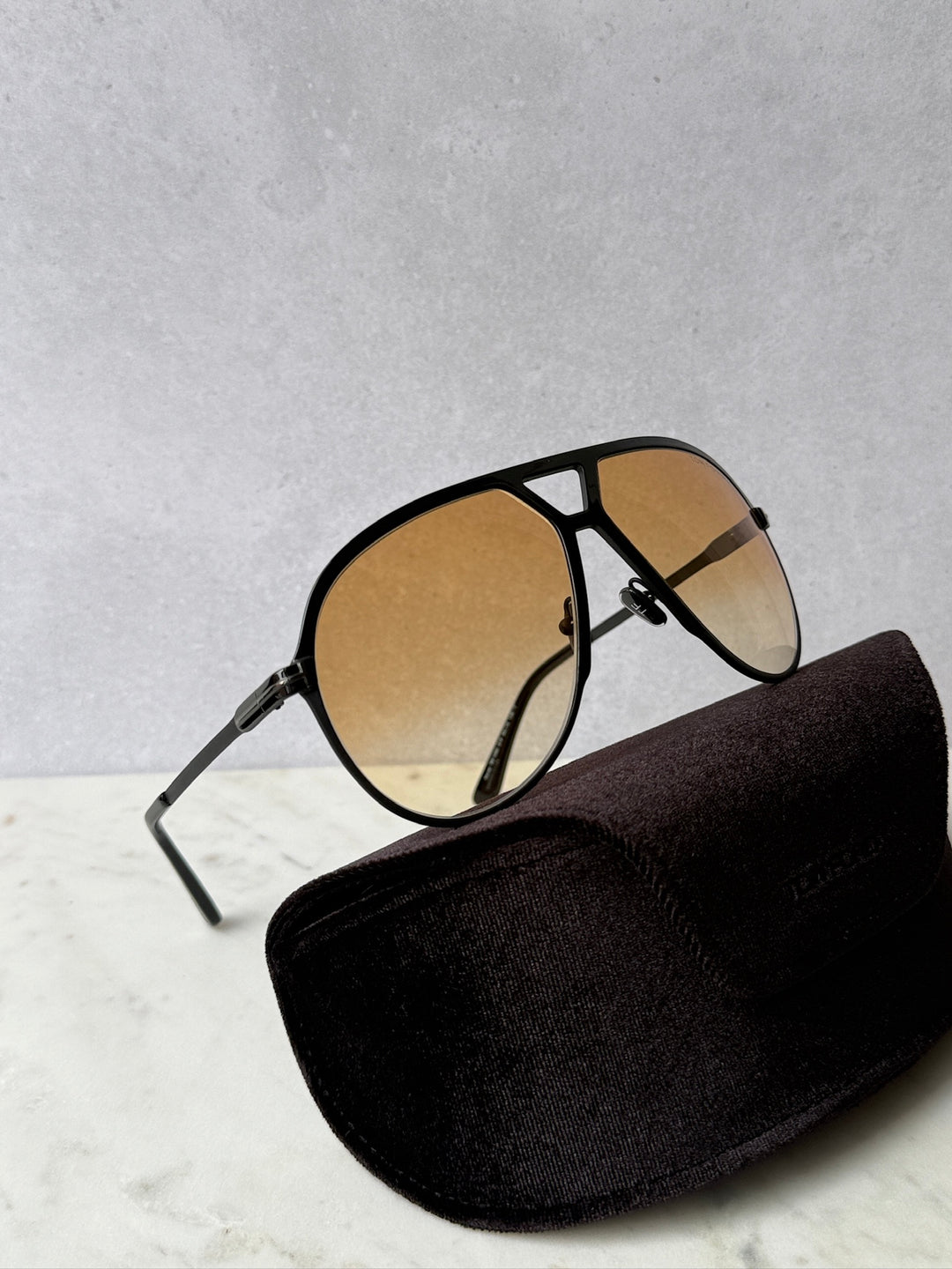 Oversized black aviator sunglasses with amber lenses and thick metal bridge