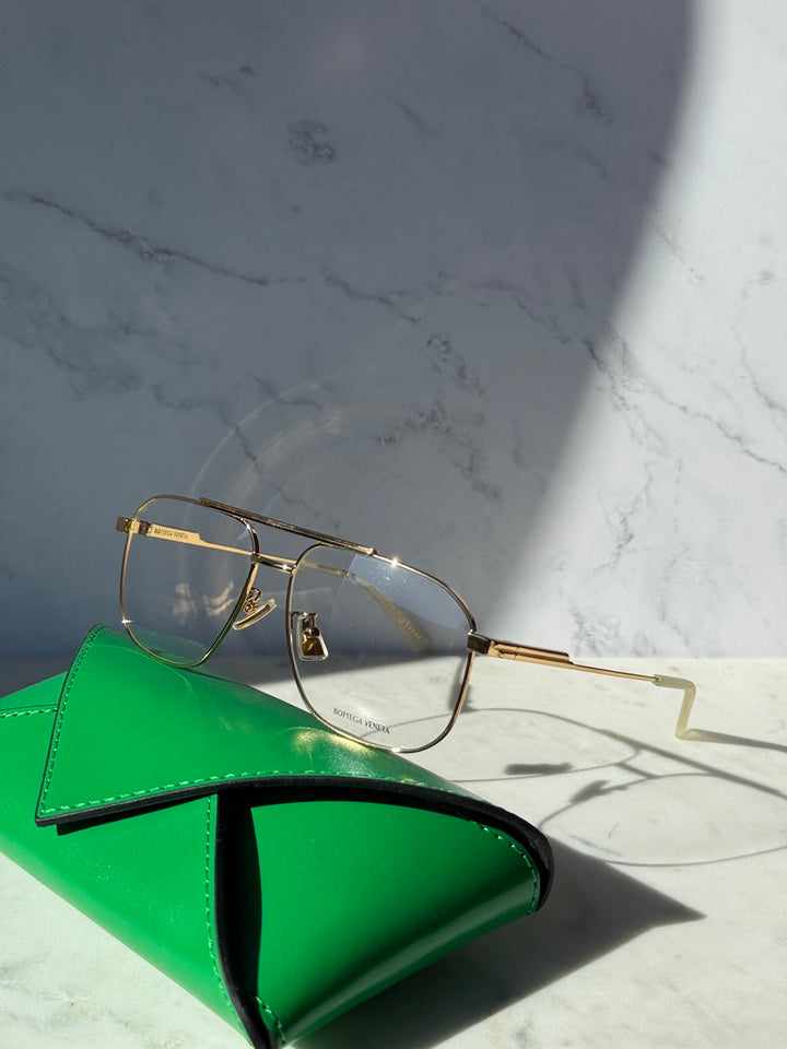 Gold pilot eyeglass frames with clear lenses and engraved temple detail