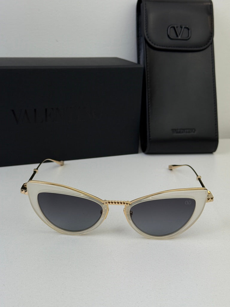 White cat-eye sunglasses with gold-tone frame and gray lenses, with black case