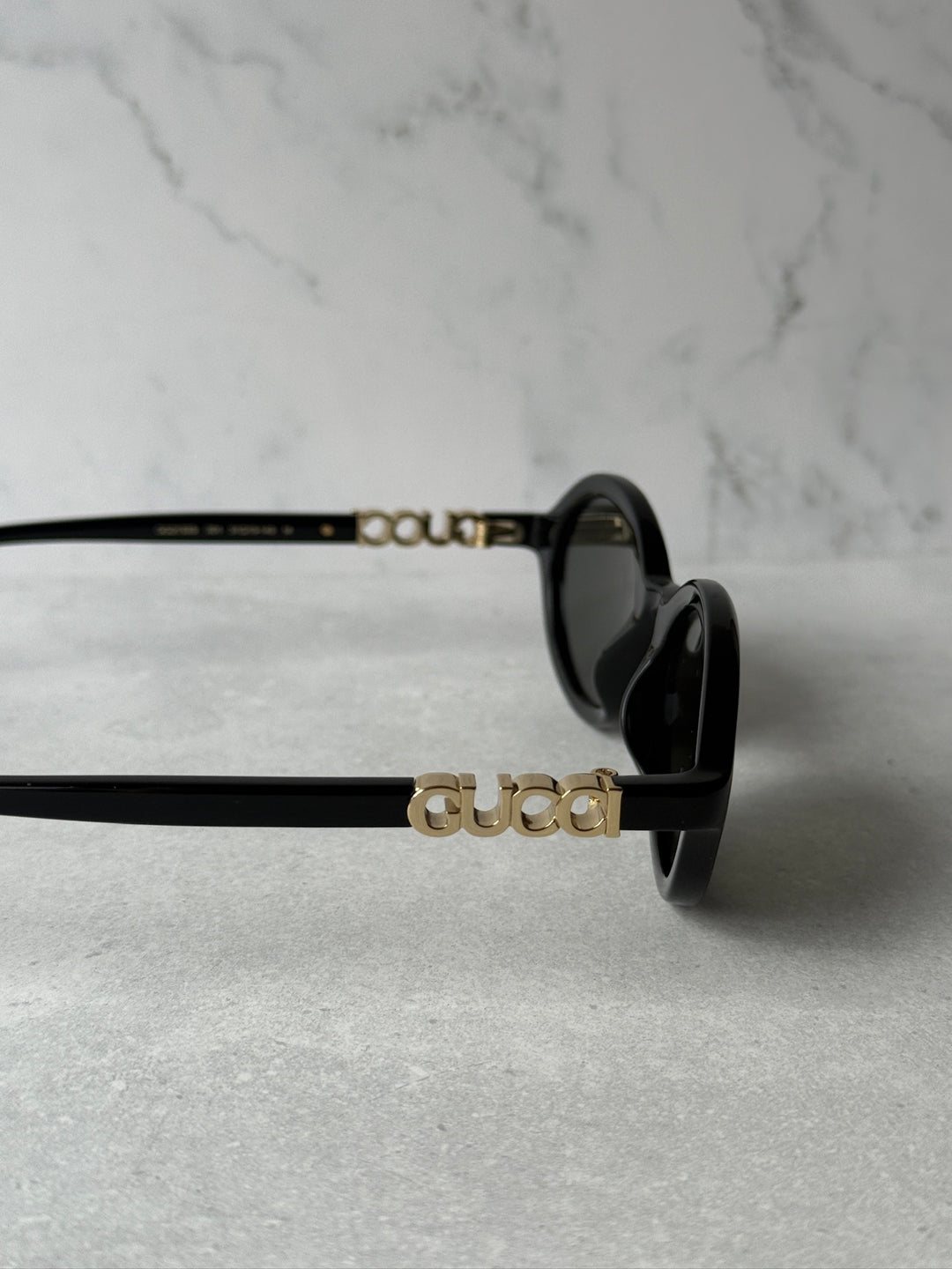 GUCCI logo detail on black sunglasses arms with dark lenses