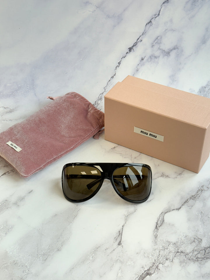 Shield sunglasses with black frames, brown lenses, and gold-tone hinge details.