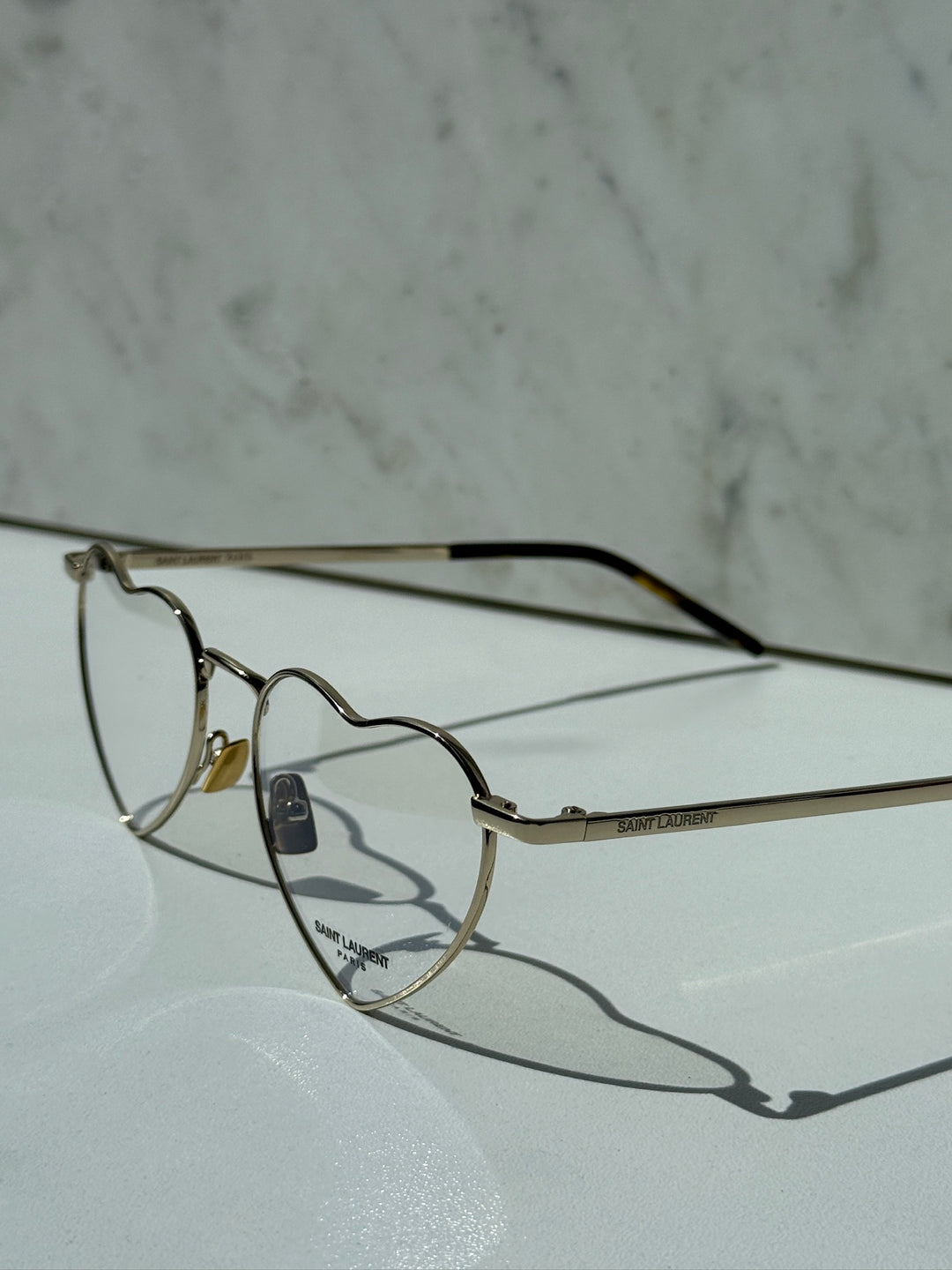 Saint Laurent LouLou optical frames in gold metal, heart-shaped clear lenses, logo arm