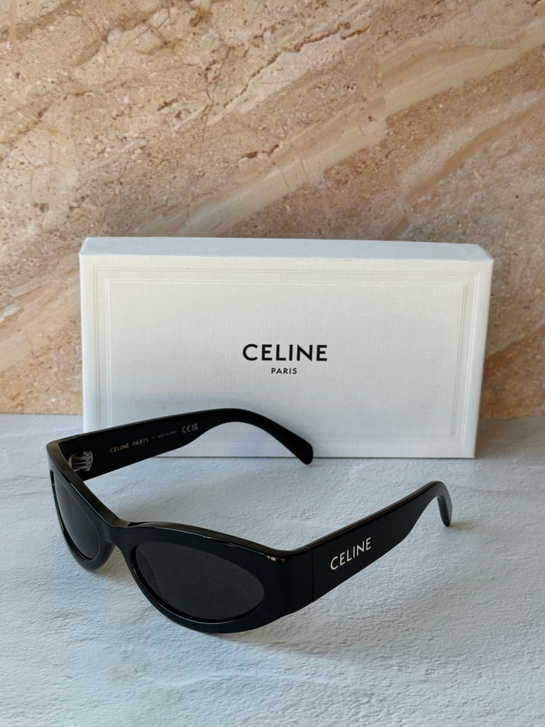 Black cat-eye sunglasses with dark lenses on white case, Celine branding