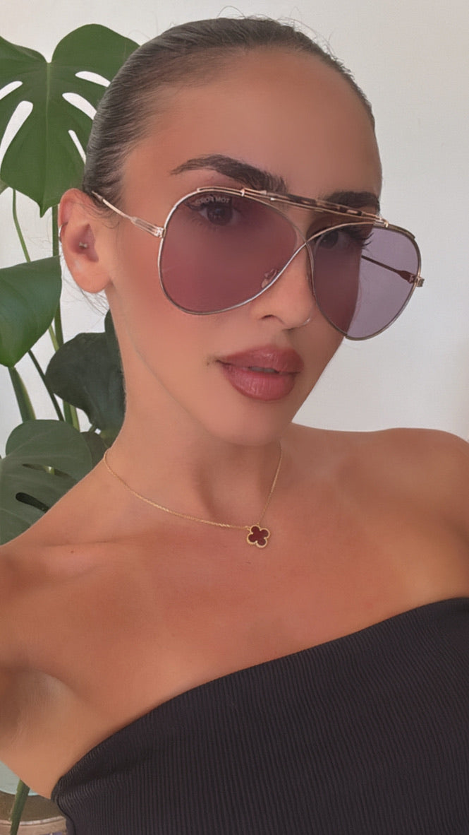 Gold aviator sunglasses with purple lenses worn by model, thin metal frame