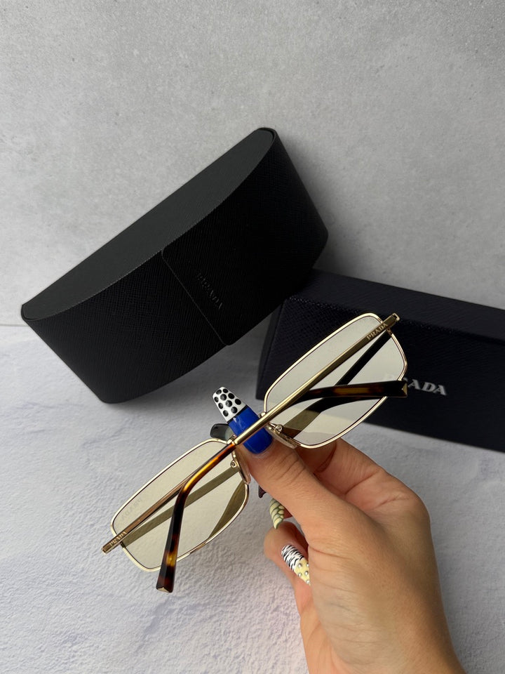 Gold metal rectangular sunglasses with brown-tinted lenses and black case.