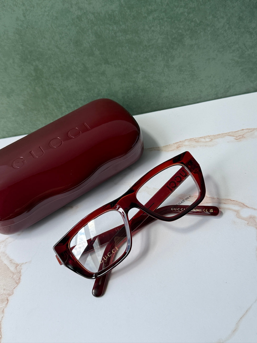 Dark red Gucci eyeglass frames with matching red case