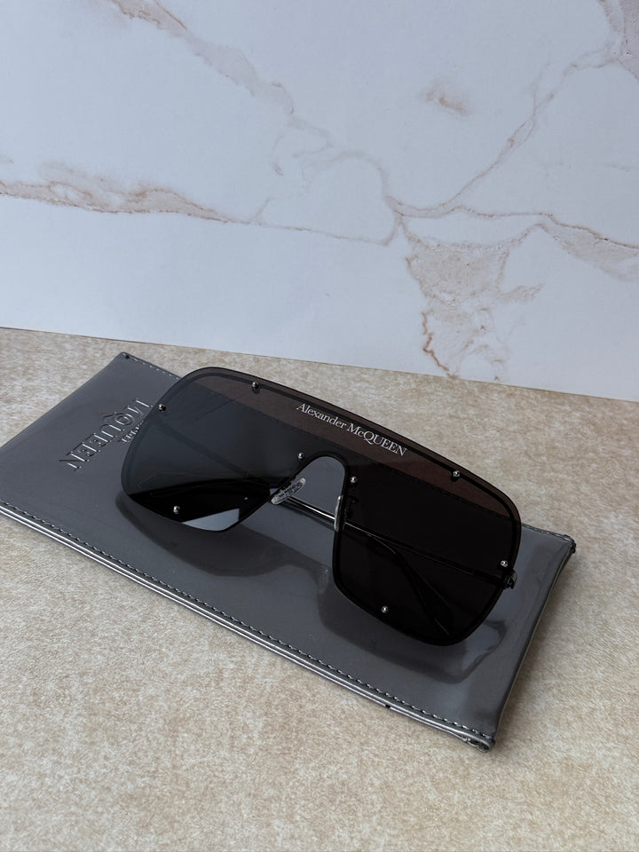 Oversized studded mask sunglasses with black frames and dark tint lenses