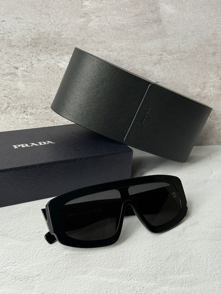 Black PRADA sunglasses with dark lenses, thick geometric frame