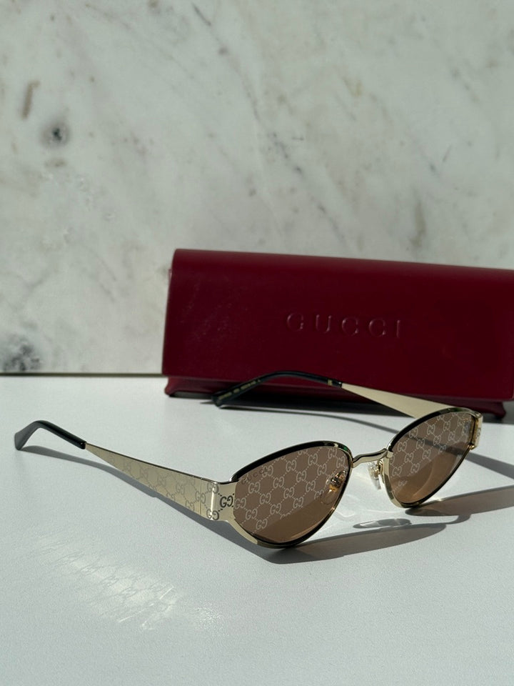 Gucci cat-eye sunglasses, GG monogram brown lenses with gold-tone frame and black tips