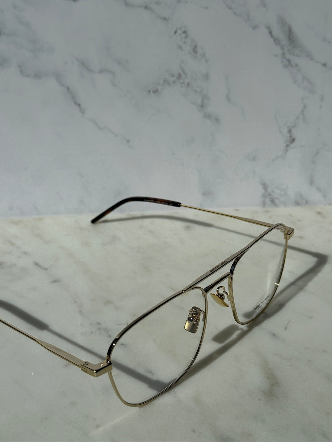 Gold aviator eyeglass frames with clear lenses and extended metal temple arm.