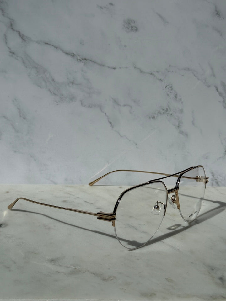 Gold aviator eyeglass frames with clear lenses and dark temple tips