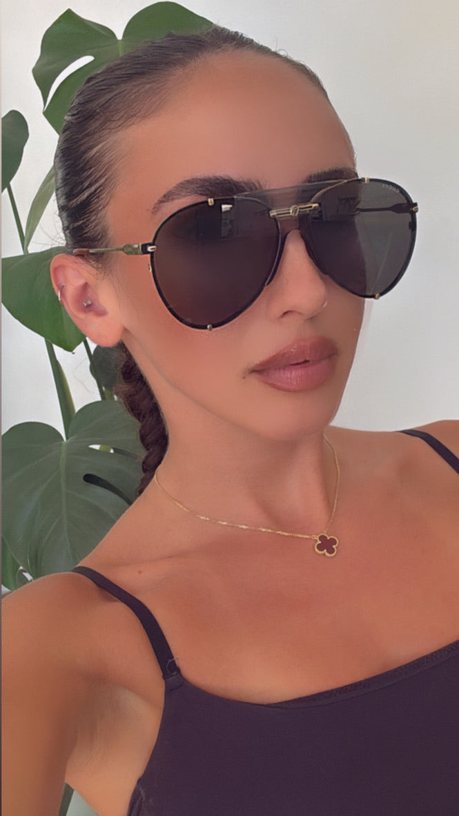 Women wearing Gucci aviator logo sunglasses with dark lenses and gold-tone frame