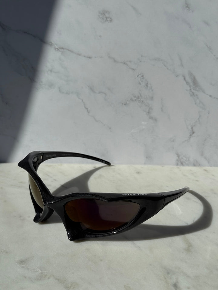 Black runner sunglasses with dark tinted lenses and slim curved wrap frame