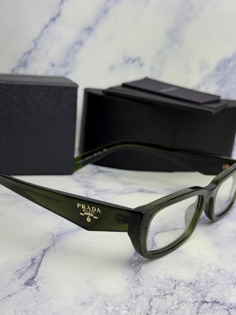 Transparent green eyeglass frames, side profile with Prada logo on the temple arm.