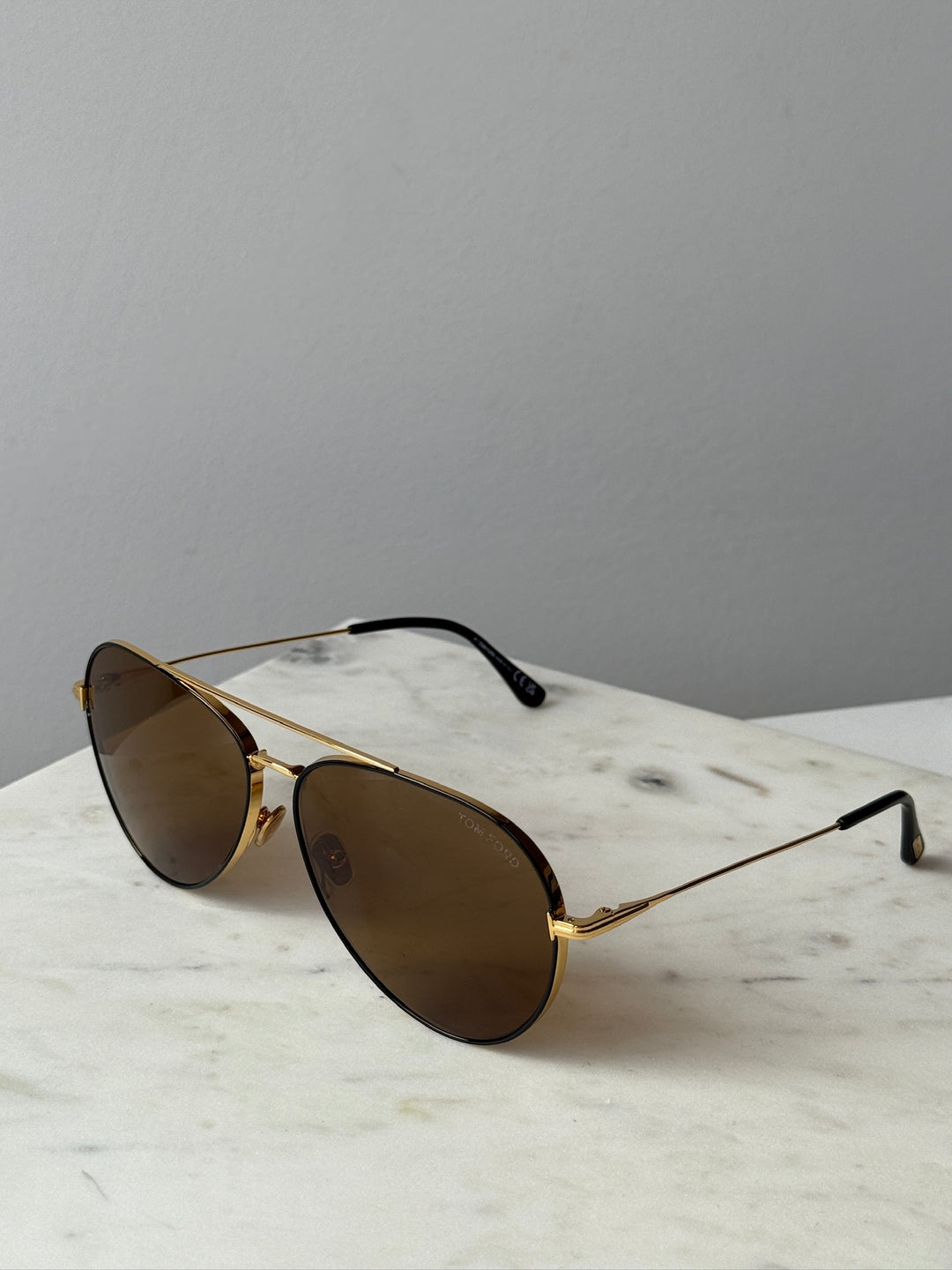 Gold-tone aviator sunglasses with brown lenses and black ear pieces