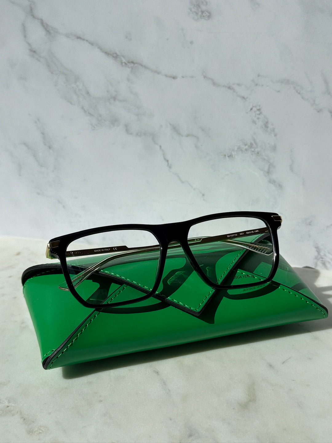 Black rectangular eyeglass frames with gold-tone temples and full-rim design.