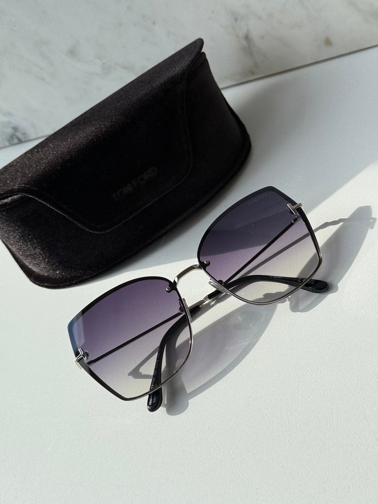 Silver grey sunglasses with dark gradient lenses near a black protective case
