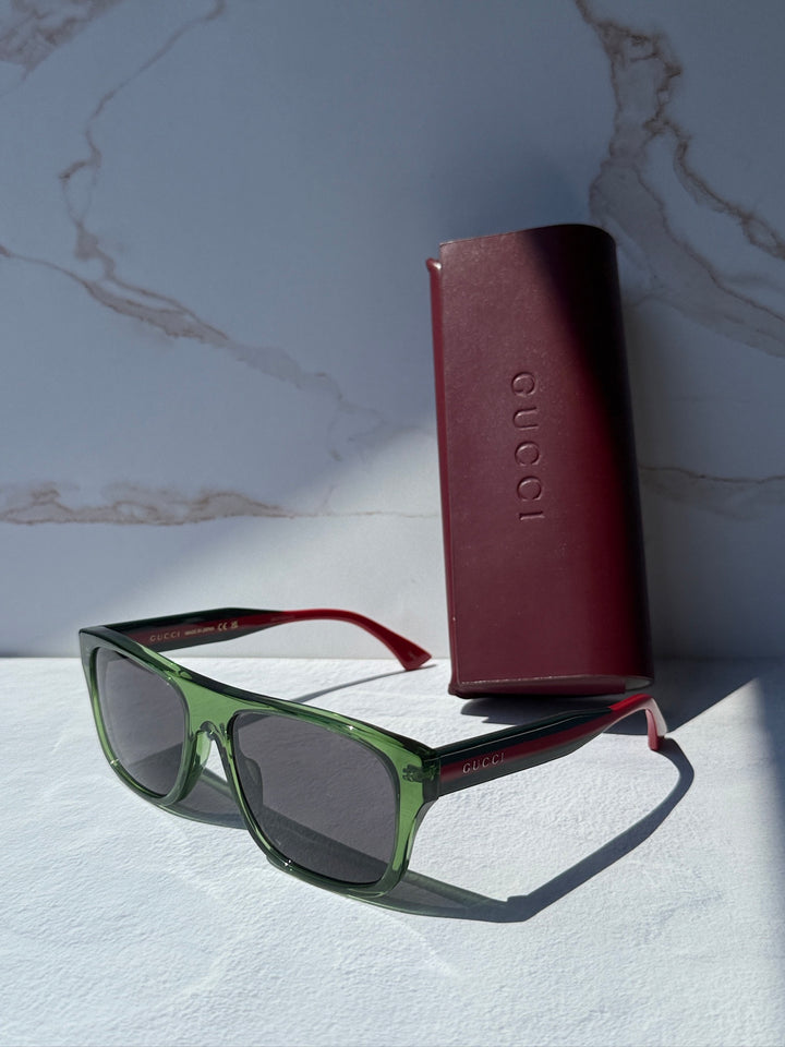 Gucci striped green sunglasses with dark lenses and red temples, with hard case.