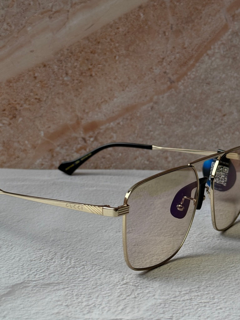Gucci gold metal pilot sunglasses with photochromic lenses, close-up side profile