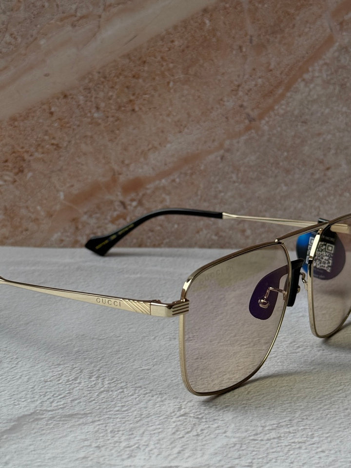 Gucci gold metal pilot sunglasses with photochromic lenses, close-up side profile