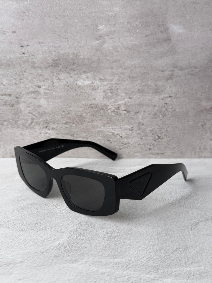 Black PRADA square sunglasses with dark lenses, side profile view